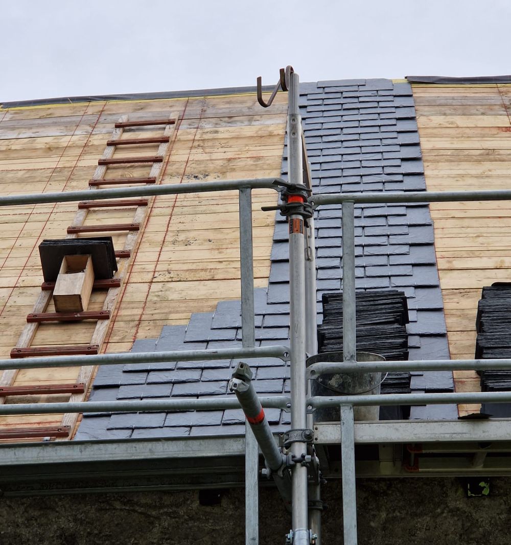 Couvreur posant une couverture en ardoises, près de Lannion en Bretagne Couvreur posant une couverture en ardoises, près de Lannion en Bretagne